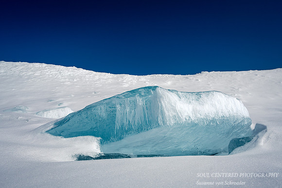 Huge blue ice piece in snow